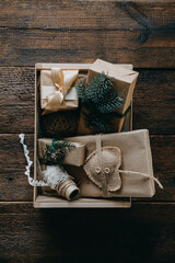 Sustainable Christmas, zero waste gifts, natural xmas decorations. Wrapping Christmas gifts in recycled brown paper in wooden care box. Vintage style Christmas packaging ideas