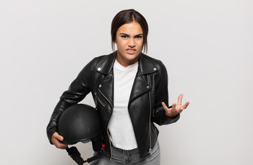 young hispanic woman looking angry, annoyed and frustrated screaming wtf or what’s wrong with you