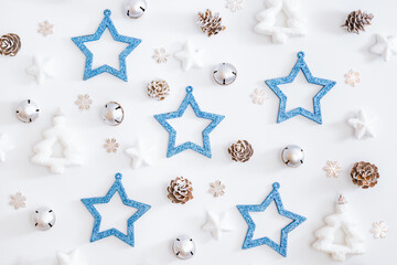 Flat lay pattern with stars, christmas baubles decoration and snowflakes on a white background