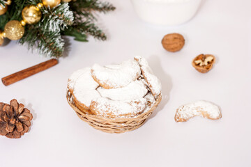 Traditional Austrian and German crescent-shaped Christmas pastries - Vanillekipferl - on a white table with Christmas decorations