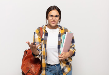 young hispanic woman looking angry, annoyed and frustrated screaming wtf or what’s wrong with you