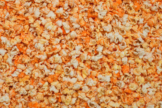 Orange popcorn with cheese or caramel top view. Flat photo.