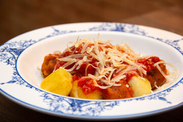 Gnocchi. Roasted Italian pasta with tomato sauce, parmesan cheese and meatballs.