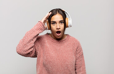 young hispanic woman looking happy, astonished and surprised, smiling and realizing amazing and...