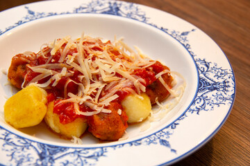 Gnocchi. Roasted Italian pasta with tomato sauce, parmesan cheese and meatballs.