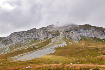beautiful autumn mountain landscape with rocky peak in the clouds