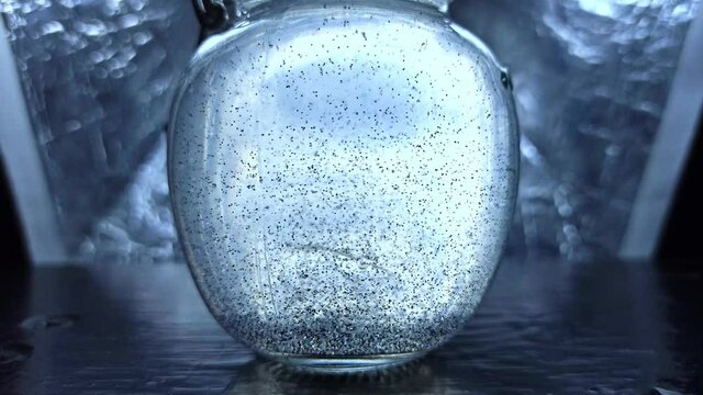 Snowfalls in festive snowglobe. Traditional winter holiday and new year decoration, crystal with snow, snowflakes inside. Christmas magical toy snow ball.