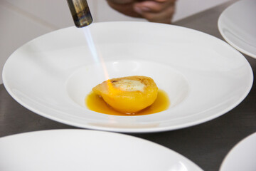 Preparing dessert of pear brulee with dolce gorgonzola cheese