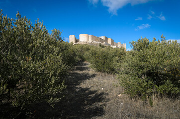 Fototapeta na wymiar Castle palace of Jadraque on the top of the hill on a blue sky day with clouds, Guadalajara, Spain