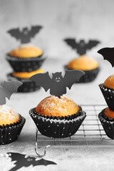 Halloween pumpkin muffins in black capsules decorated with cardboard bats. Festive Halloween...