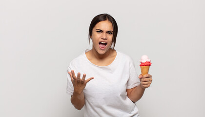young hispanic woman looking angry, annoyed and frustrated screaming wtf or what’s wrong with you