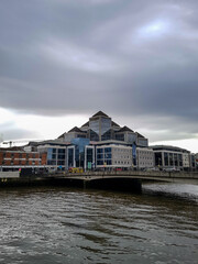 Fototapeta na wymiar Iluminati building next to the river and bridge in Dublin, Ireland 