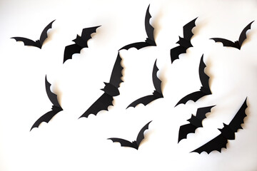 halloween, decoration and scary concept - black paper bats flying over white background.  Halloween paper bats on white background. Halloween decorations on white background. Halloween concept.