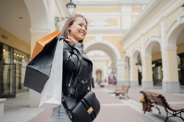 Holds bags of shopping bags in the store on sale. a young woman of Caucasian appearance bought gifts for her family, father, mother, sister, brother, daughter, son.