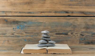 books and stack of zen stones on wood table background. Feng Shui, Balance and relaxation concept. Harmony and balance