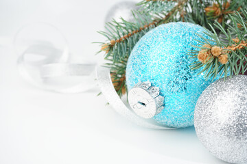 Christmas card with Christmas toys blue, turquoise and silver balls, Christmas tree branches,...