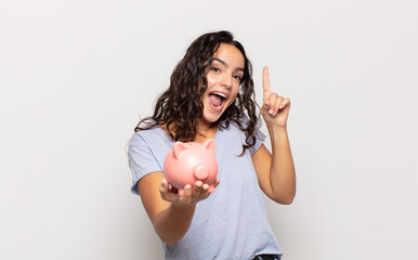 young hispanic woman feeling like a happy and excited genius after realizing an idea, cheerfully...