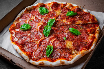 Pepperoni Pizza with Mozzarella cheese, salami, Tomato sauce, pepper, Spices and Fresh basil. Italian pizza on wooden table background