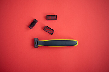 Beard trimmer with three attachments on the red background. 