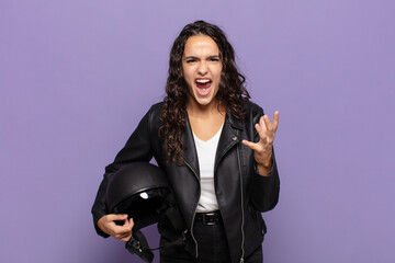young hispanic woman looking angry, annoyed and frustrated screaming wtf or what’s wrong with you