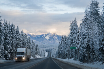 Truck driving through the rocky mountains in  winter on the Trans Canada Highway in British...