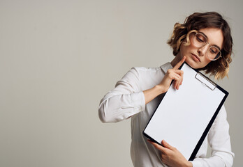 Naklejka premium Woman with a white sheet of paper in a folder with short hair Copy Space