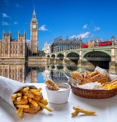 Big Ben against fish and chips served on the table in London, England, United Kingdom