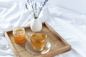  A cup of tea in the morning on wooden tray in bed.