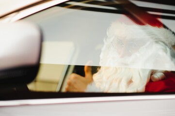 Authentic Santa Claus driving his modern car, outdoors