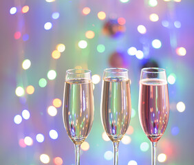 Three glasses of champagne with lights in the background.