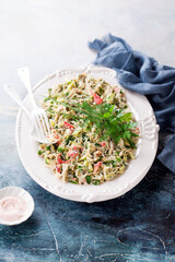 Crab meat salad with avocado, cucumber, green onion and dill on a plate, selective focus