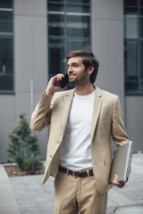 Bearded businessman using mobile for conversation outdoors