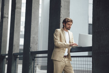 Serious man working on laptop near business center