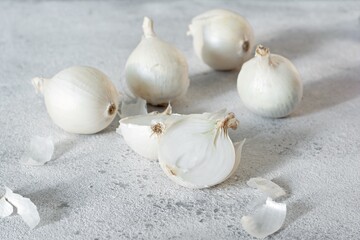 Organic sweet white onion on a gray background with hard shadows, farm harvest, healthy vegetable.