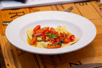Ravioli with pieces of fresh tomato dipped in olive oil