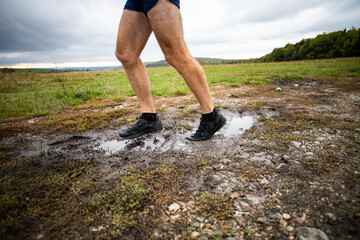 feet of trail runner running in nature