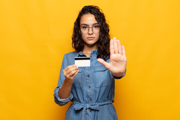 young hispanic woman looking serious, stern, displeased and angry showing open palm making stop gesture - obrazy, fototapety, plakaty