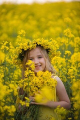 Little cute blonde girl on a rapeseed field