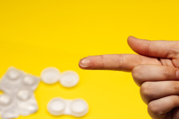 contact lenses  in packaging and on a finger on a yellow background. Lenses for every day.