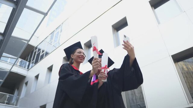 Two graduates take a selfie. Capturing happy moments.