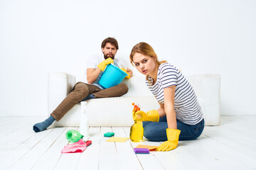 Young couple are doing cleaning together in the room light background