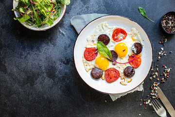 fried eggs scrambled with tomato and black pudding sausage nutritious breakfast on the table tasty serving size portion top view copy space for text