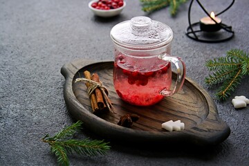 Hot drink, cranberry tea in a glass teapot or mug on a dark concrete background. Berry teas. Copyspace