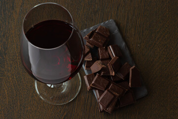 Red wine and chocolates on a wooden table