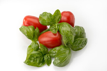 Fresh ripe tomatoes with basil leaves, isolated on white background