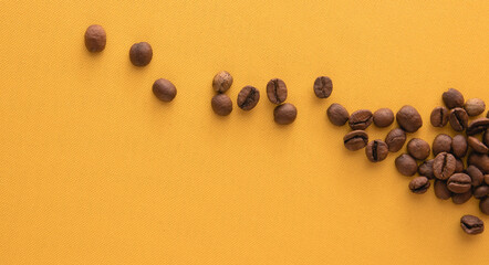 Coffee beans on yellow background. Top view with copy space for text