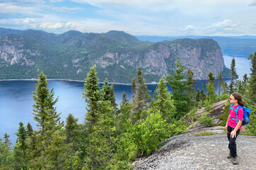 Girl hiker admiring Saguenay Fjord from Saguenay Fjord from an aerial viewpoint in Quebec, Canada