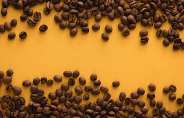 Coffee beans isolated on yellow background. Top view with copy space for text