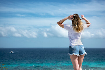 Fototapeta na wymiar beautiful woman on the beach looking on the horizon