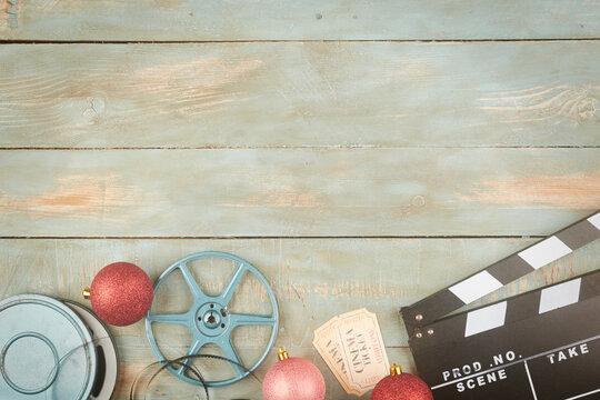 red christmas balls and cinema objects on wooden background